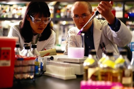 Male and female technicians performing a scientific experiment in lab
