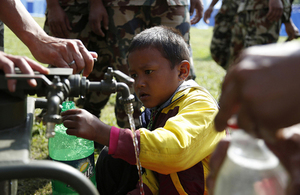 A Nepalese boy collects clean water from a pump installed by British Gurkhas after the earthquake which struck Nepal on 25 April 2015. Picture: Jess Lea/DFID