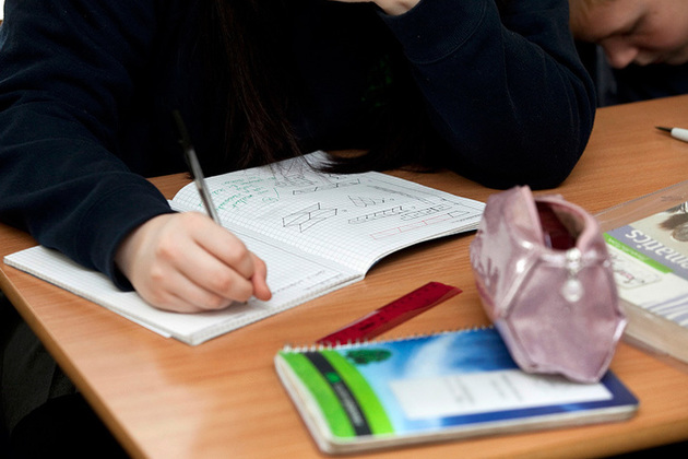 Student writing in a maths exercise book