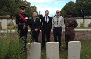 Guy Boxall (son of Gary Boxall), Gary Boxall great grandson of CSM Gale and representatives stand by CSM Gale's headstone - Crown Copyright - All rights reserved