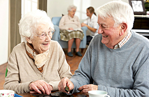 An elderly couple playing dominoes