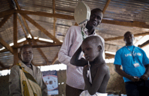 A child is weighed as part of a nutritional assessment in Unity State, South Sudan, December 2016. Picture: UNICEF/Kate Holt