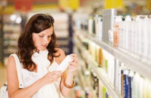 A woman looking at a beauty product in a shop.