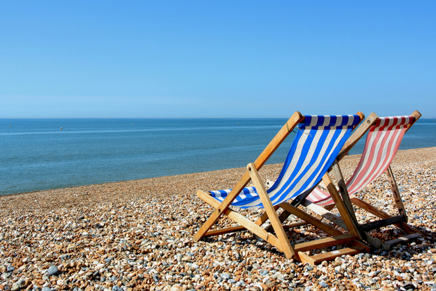 deckchairs facing out to sea on a pebble beach
