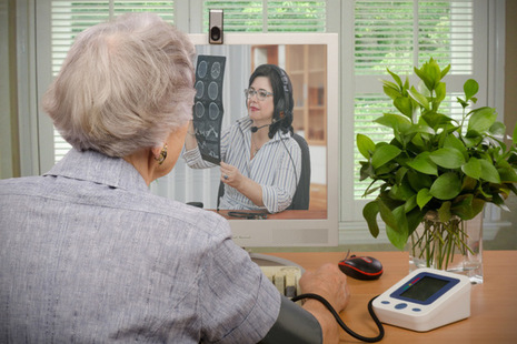 Older person speaking to their GP over a webcam.