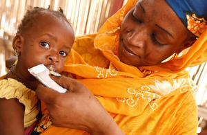 Woman feeding child in the Sahel