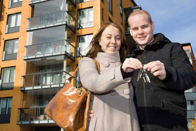 A young couple hold the keys to their newly purchased home
