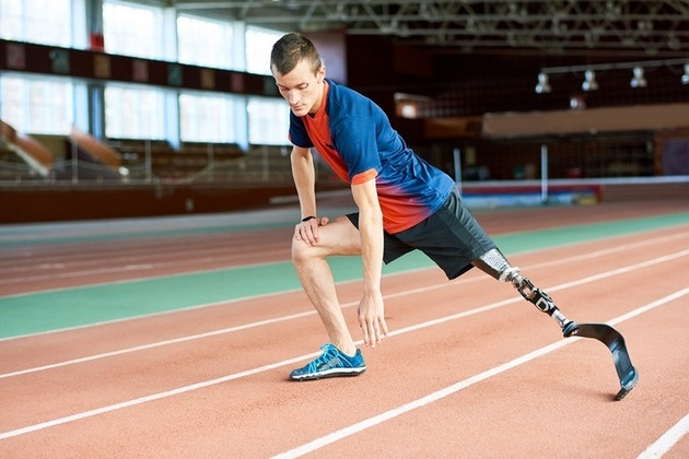Boy on running track with prosthetic leg