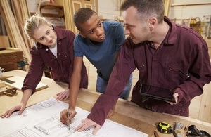 carpenter with apprentices in workshop