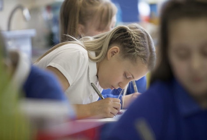 Female pupil writing.