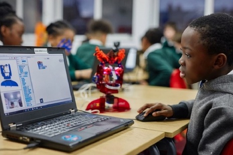 Image of school child learning to code using the Ohbot robot technology.