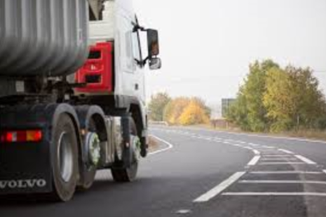 Photograph of a red lorry driving on a road