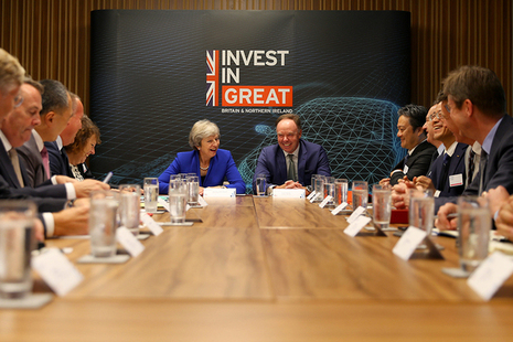 Prime Minister Theresa May at the head of the Automotive Investment Roundtable with "Invest In GREAT" banner in the background