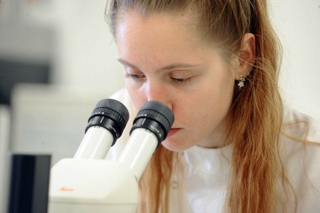 Female scientist looking through a microscope