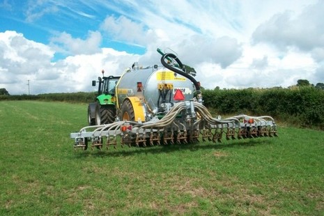 Tractor towing slurry injector in field