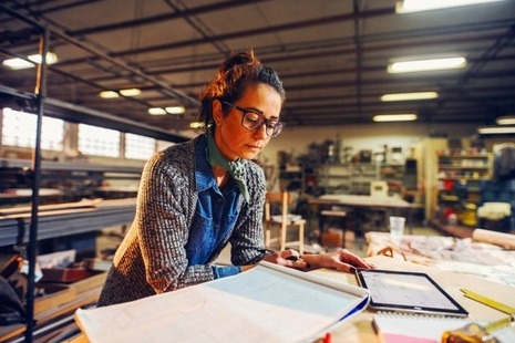 An engineer reviews plans in her workshop