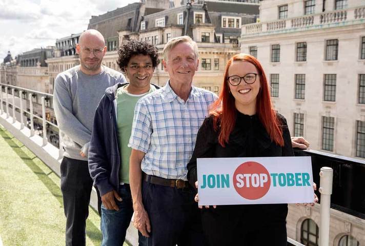 Group of people holding up banner saying 'Join Stoptober'