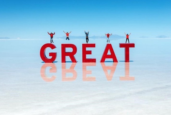 People jumping on GREAT sign on Bolivian salt flats