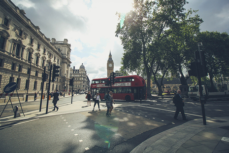 Photo of people crossing street with the Palace of Westminster in the background