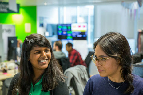 Two young woman sat next to each other in the GDS office