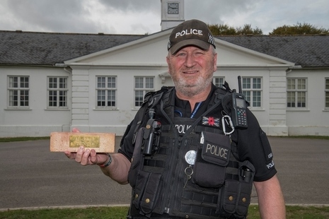 PC Paul Corcoran with one of the bricks inscribed and made by Dstl apprentices