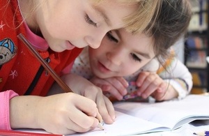 Primary school aged girls writing in books