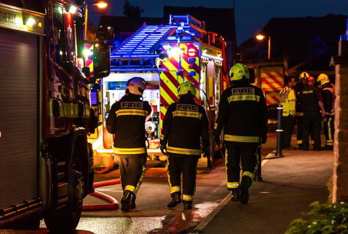 Firefighters walk towards an engine