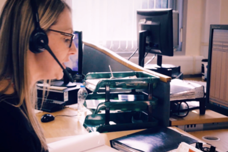 woman sitting by computer with headphones