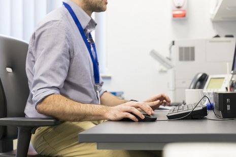 GP using computer at desk