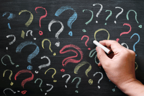 Questions marks on a black chalkboard