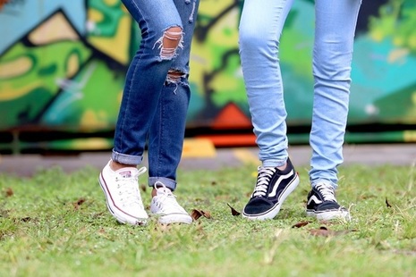 Two teenagers, seen from the legs down, standing on grass