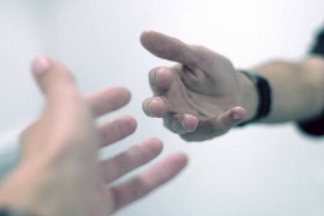 2 hands reaching out towards each other.