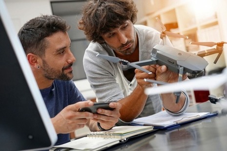Two technicians work together on a drone