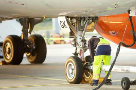 Support services working on an airplane on the runway.