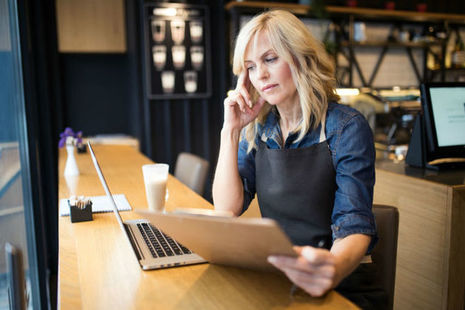 Image of coffee shop owner using a laptop