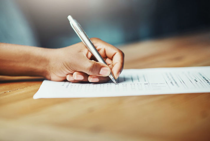 Image of someone filling out a form