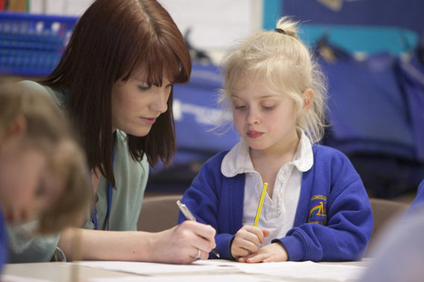 Teacher writing with female pupil