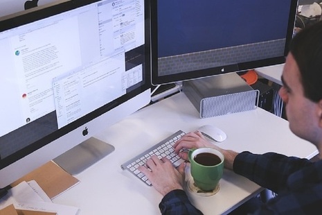 Man typing in front of a computer