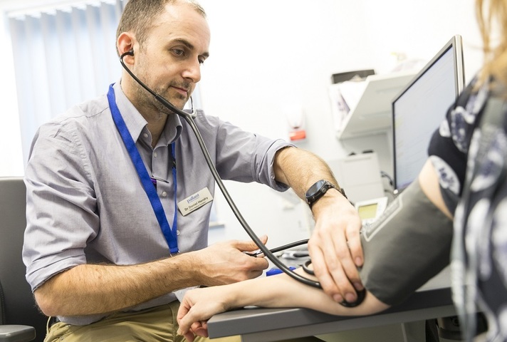 Doctor using stethoscope on patient's arm