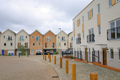 Suburban houses and flats with bollards lining the pavement.