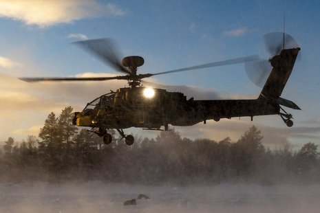 An Apache AH1D helicopter makes a landing in snowy conditions.