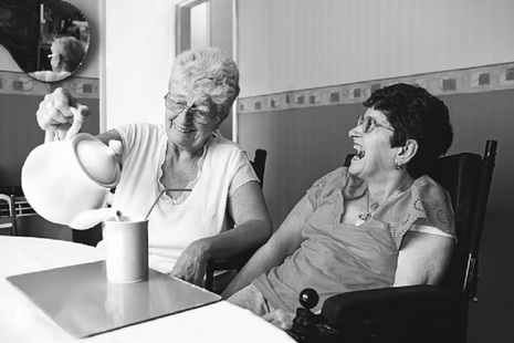 Two ladies laughing while having a cup of tea