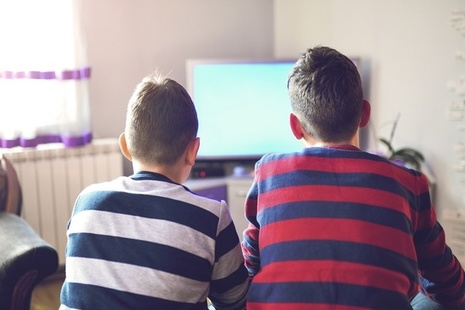 Two boys sitting in front of a television