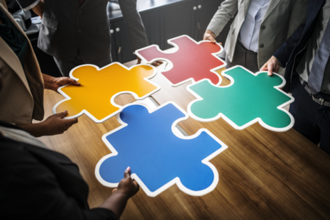 People holding pieces of a jigsaw puzzle