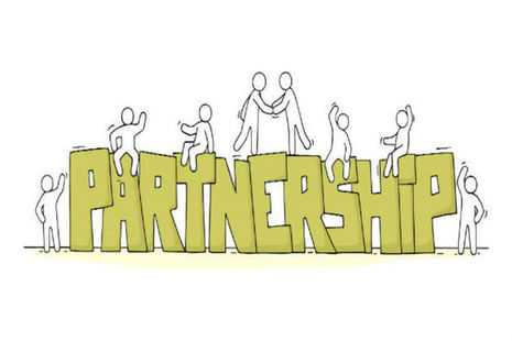 People standing on top of the word partnership shaking hands