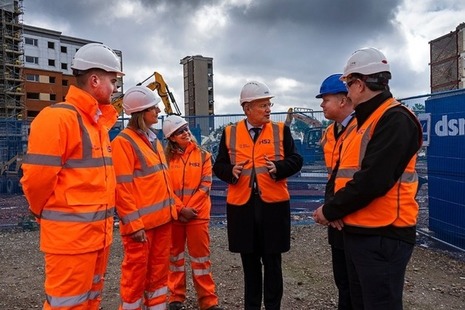 construction site vistors wearing protective clothing talking to each other