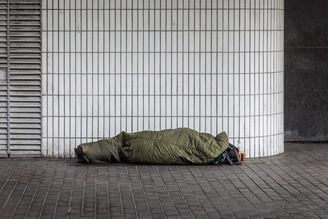 A homeless person sleeping rough in a sleeping bag.