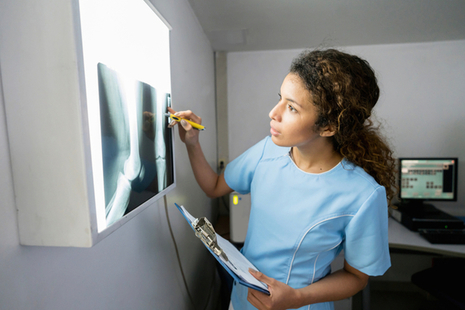 A nurse views an X-ray.