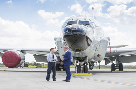 Defence Minister Stuart Andrew talking with an RAF officer in front of a miltary aircraft