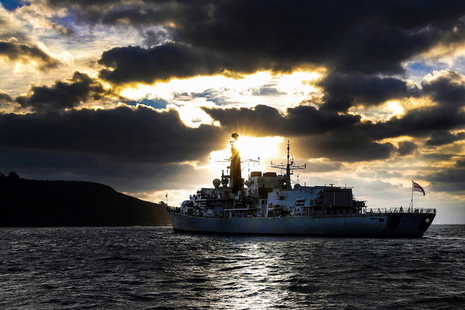HMS Monmouth sailing with a sunrise backdrop